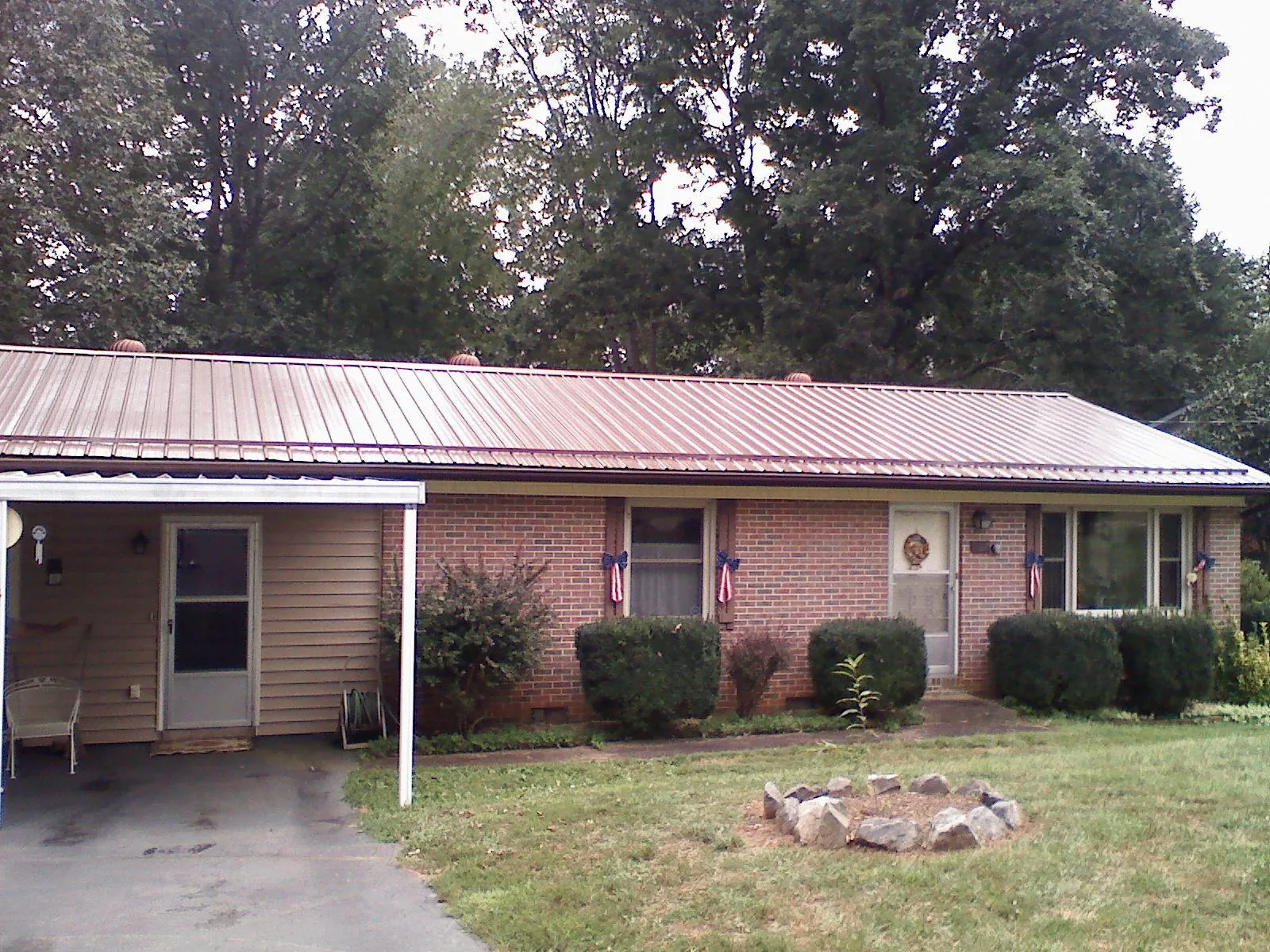 Bronze metal roof and carport on a brick ranch home — Roof Repair work by our crew in Mason
